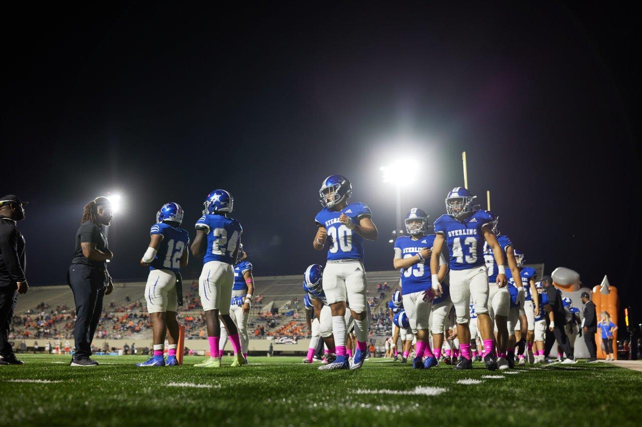 Kids playing foot ball on the field.
